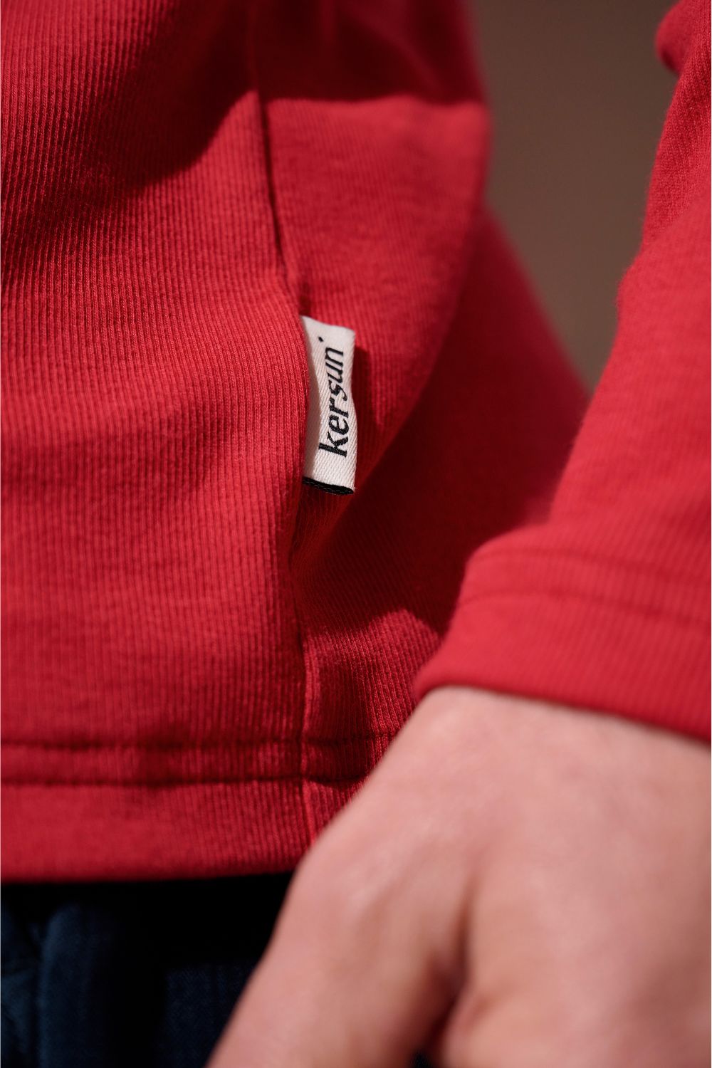 Détail d'un t-shirt anti-UV rouge Ker Sun, léger et pratique, prêt à offrir une protection solaire quotidienne.