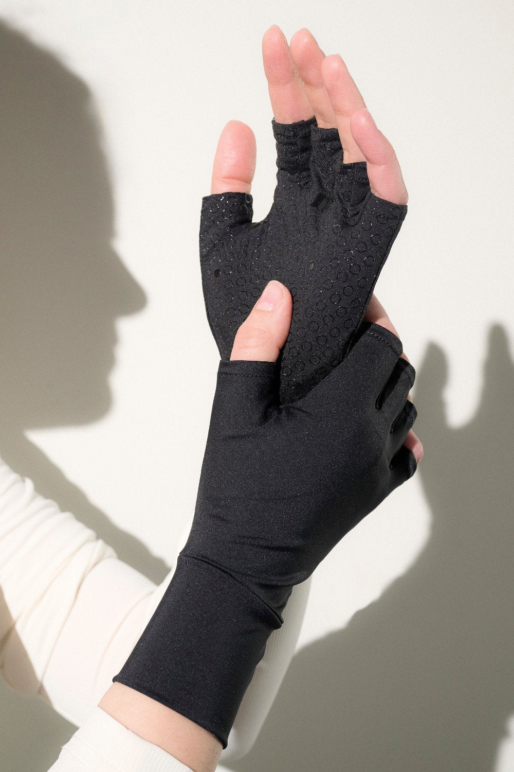 Mitaines anti-UV noires UPF50+ pour femme, offrant confort et protection solaire en extérieur.