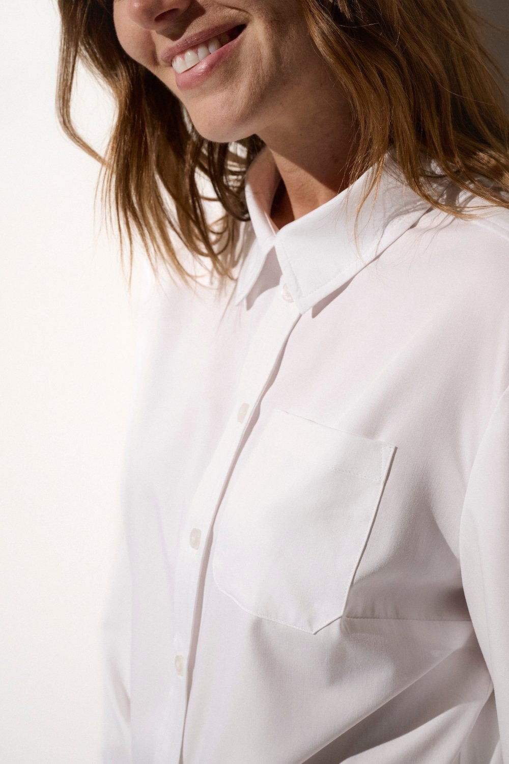 Chemise anti-UV blanche pour femme, élégante et légère, offrant une protection solaire UPF50+ pour les journées en plein air.