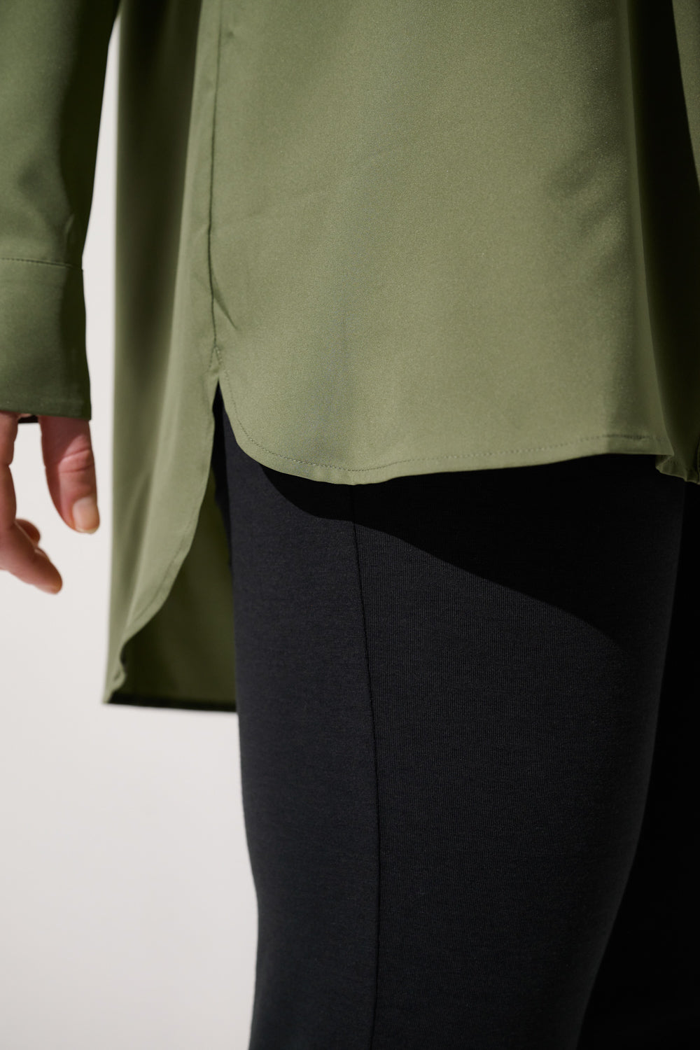 Chemise longue anti-UV - Faro vert olive, coupe droite, portée avec un legging noir, idéale pour la protection solaire.