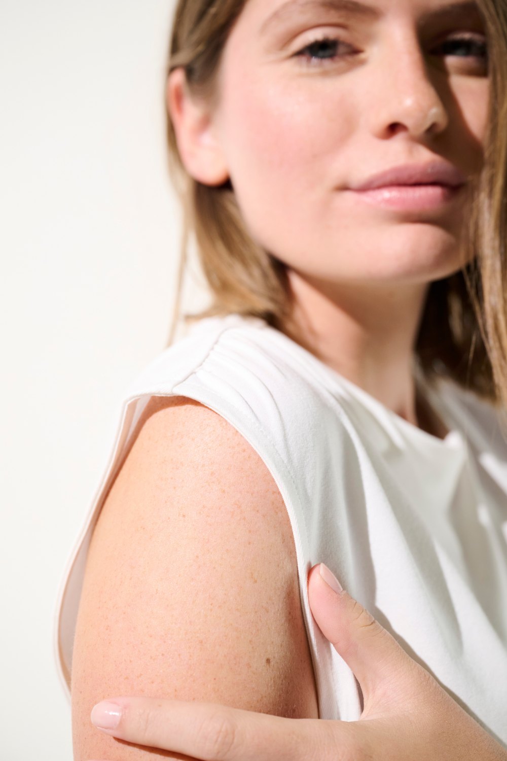 Débardeur anti-UV blanc UPF 50+ pour femme, élégant et léger, offrant protection solaire au décolleté.