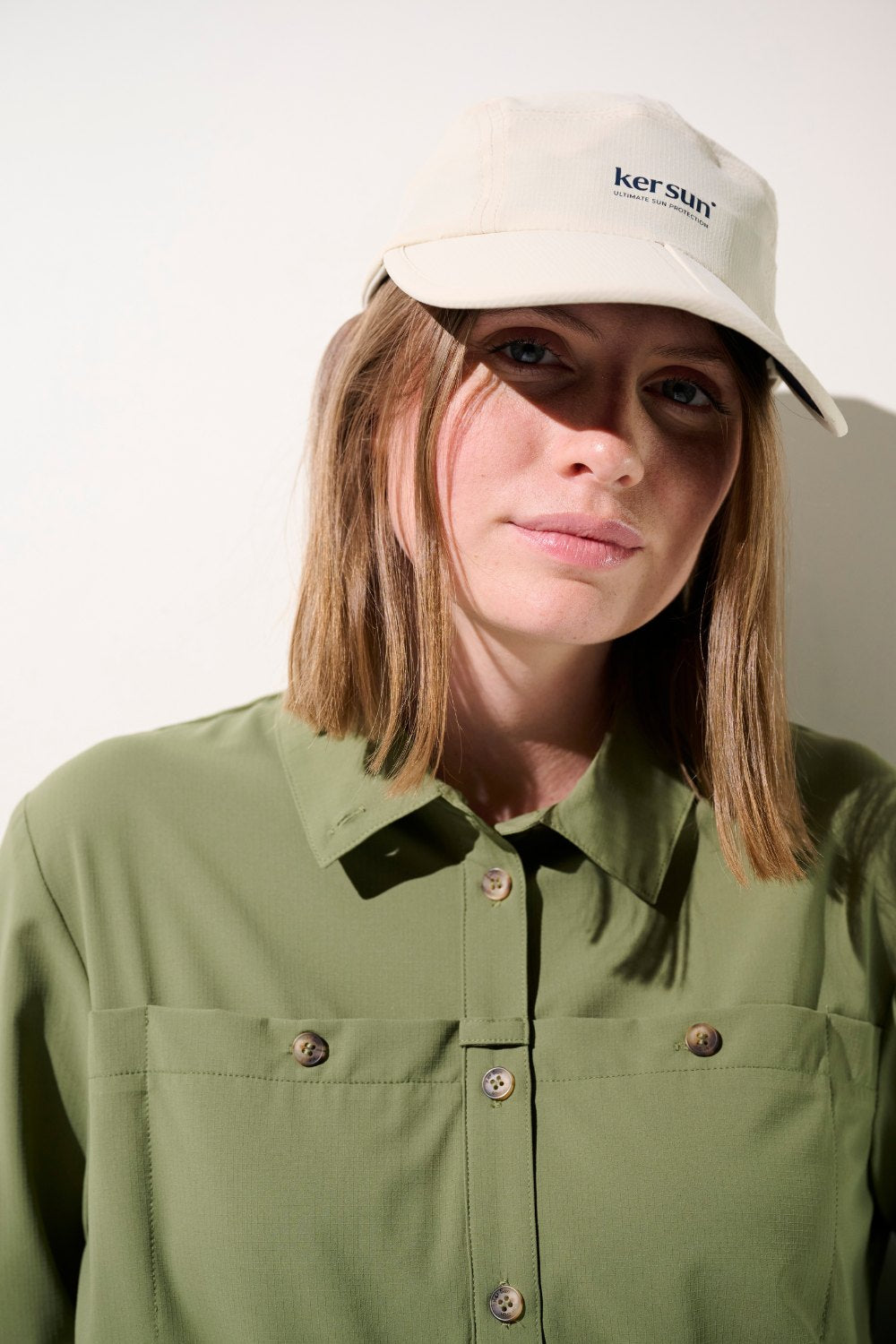 Casquette anti-UV - Sequoia beige de Ker Sun, portée par une femme avec une chemise verte, idéale pour le soleil.