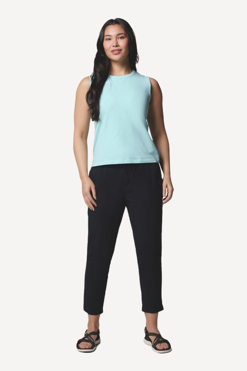 Femme portant un pantalon anti-UV noir et un débardeur bleu clair, idéal pour la protection solaire UPF50+.