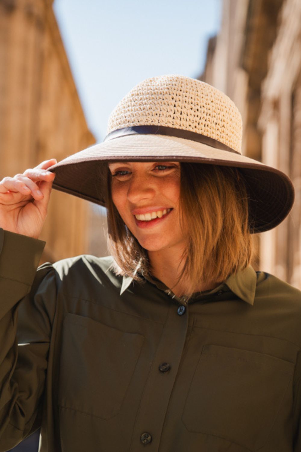 Chapeau anti-UV - Antibes, élégant et léger, porté par une femme en pleine rue pour une protection solaire optimale.