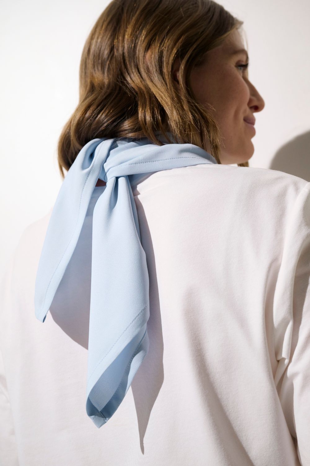 Foulard anti-UV - Positano en couleur bleue porté par une femme, élégant et léger pour protection solaire au quotidien.