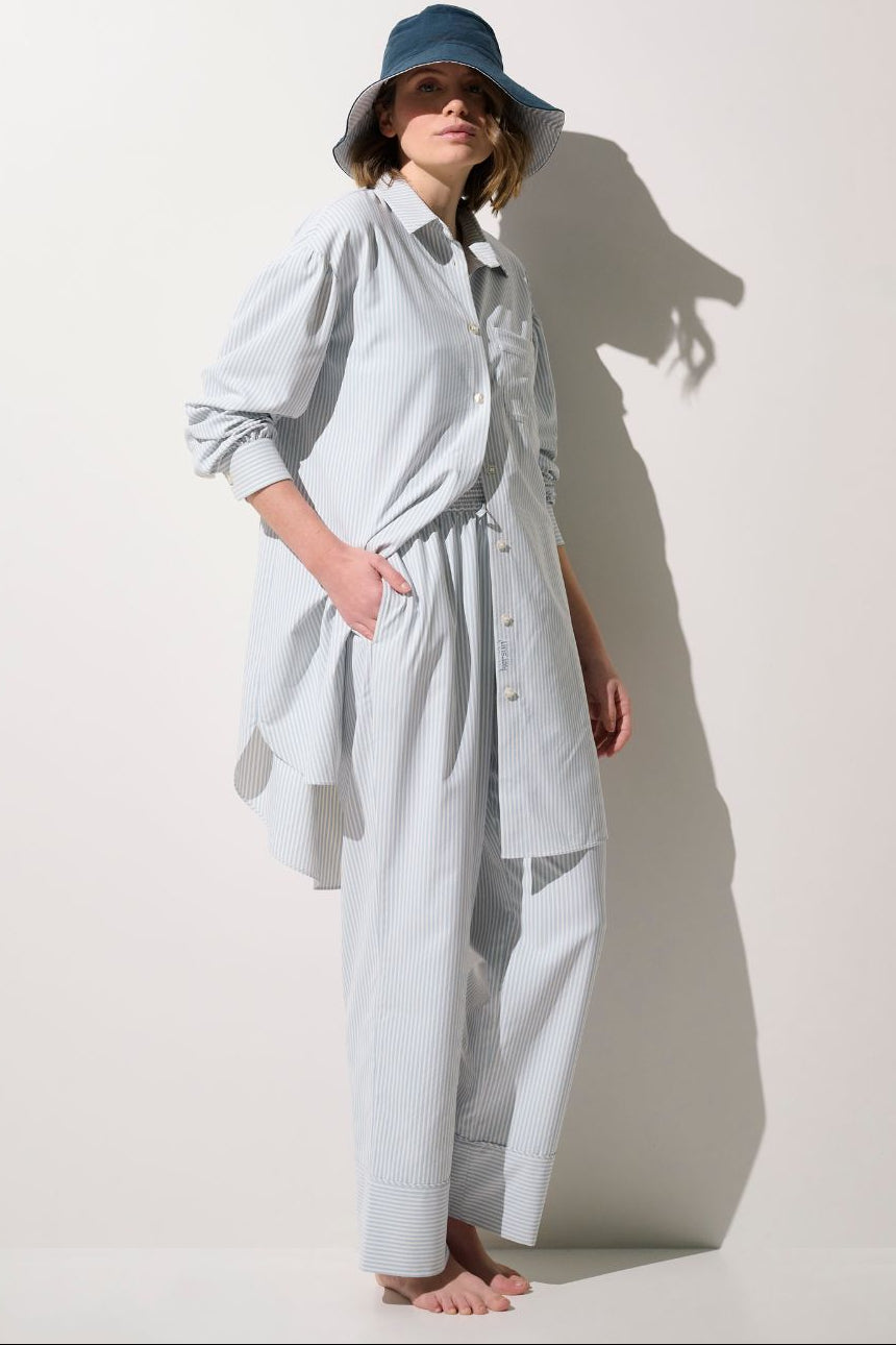 Chemise longue anti-UV - Sylt, légère et élégante, portée par une femme avec un chapeau, pour protection solaire.
