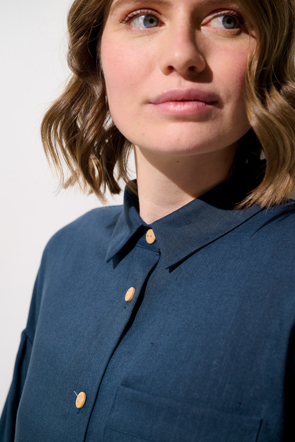 Femme portant une chemise longue anti-UV - Sylt en bleu, élégante et légère, parfaite pour la protection solaire.