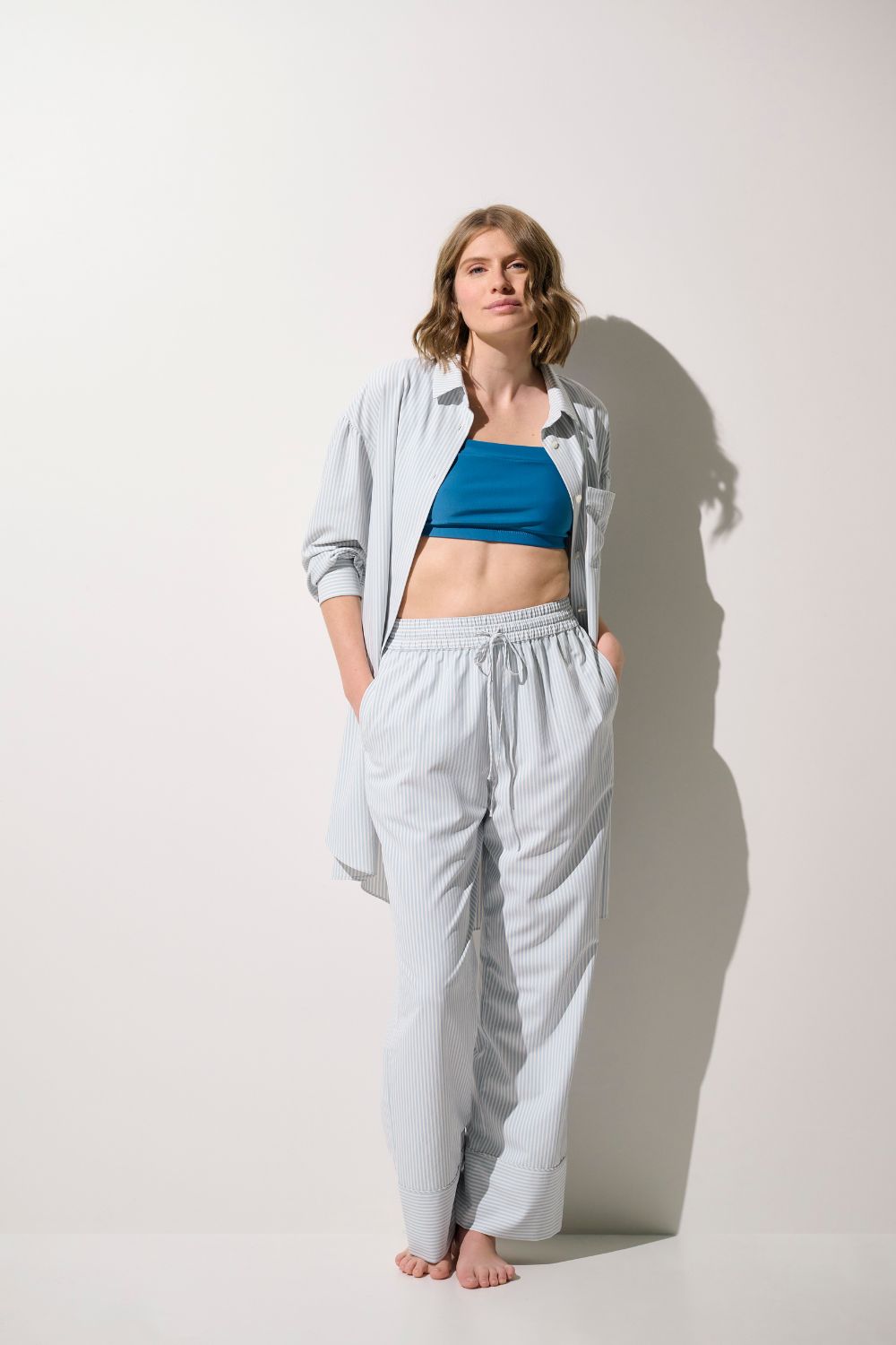 Femme portant un pantalon anti-UV - Sylt et un haut bleu, élégant et léger pour une protection solaire quotidienne.