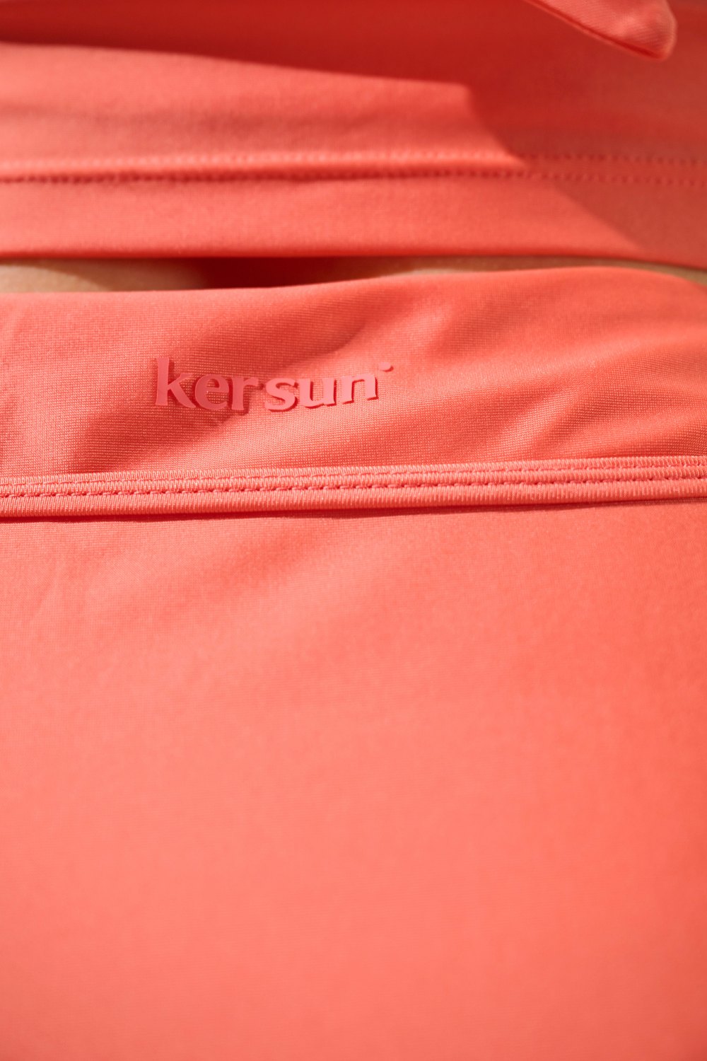 Détail d'une jupe de bain anti-UV - Capri en tissu léger corail, marque Ker Sun, offrant protection solaire.