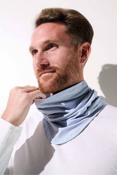 Tour de cou anti-UV Boston en bleu clair porté par un homme, offrant protection solaire UPF 50+ et confort.