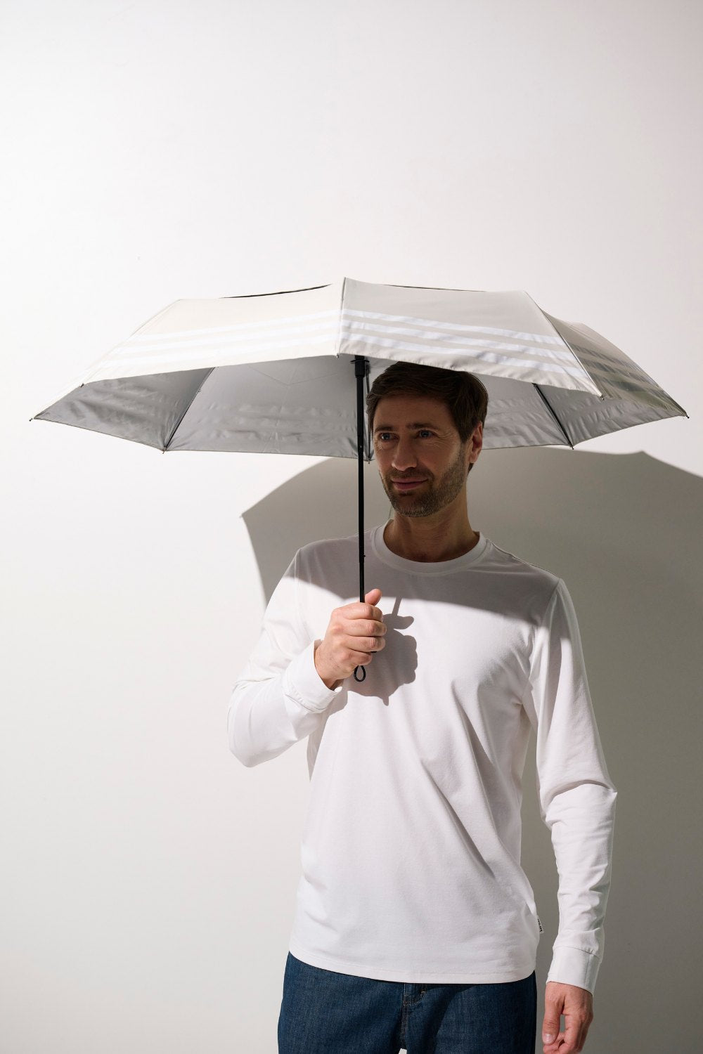 Homme portant une ombrelle anti-UV - Pornichet, en blanc, offrant une protection solaire UPF 50+.