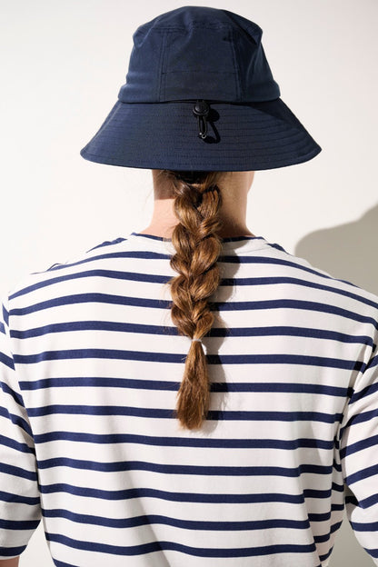 Bob anti-UV - Faro bleu marine porté par une femme, protection solaire UPF 50+ avec un style décontracté.