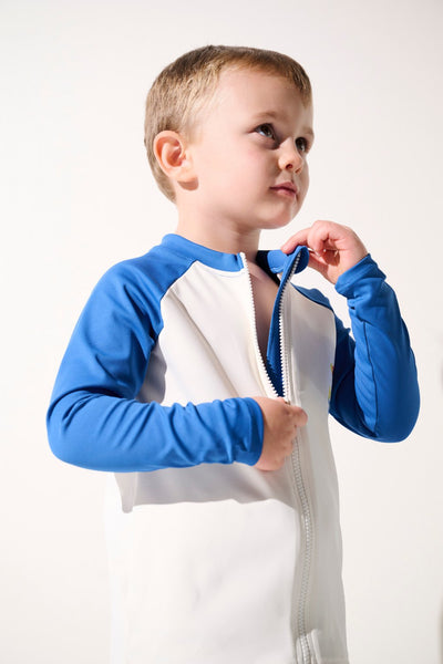 Veste de bain anti-UV - Fidji, enfant en lycra blanc et bleu, protection solaire UPF 50+ pour jeux à la plage.
