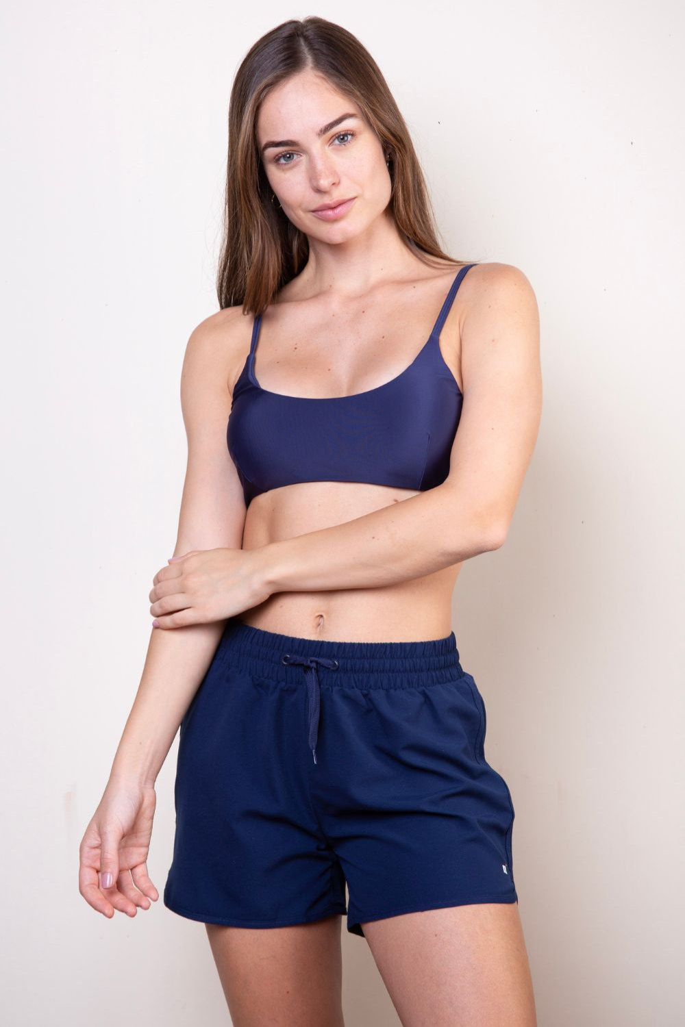 Femme portant un short de bain anti-UV bleu marine, idéal pour la plage, UPF 50+ pour une protection solaire optimale.