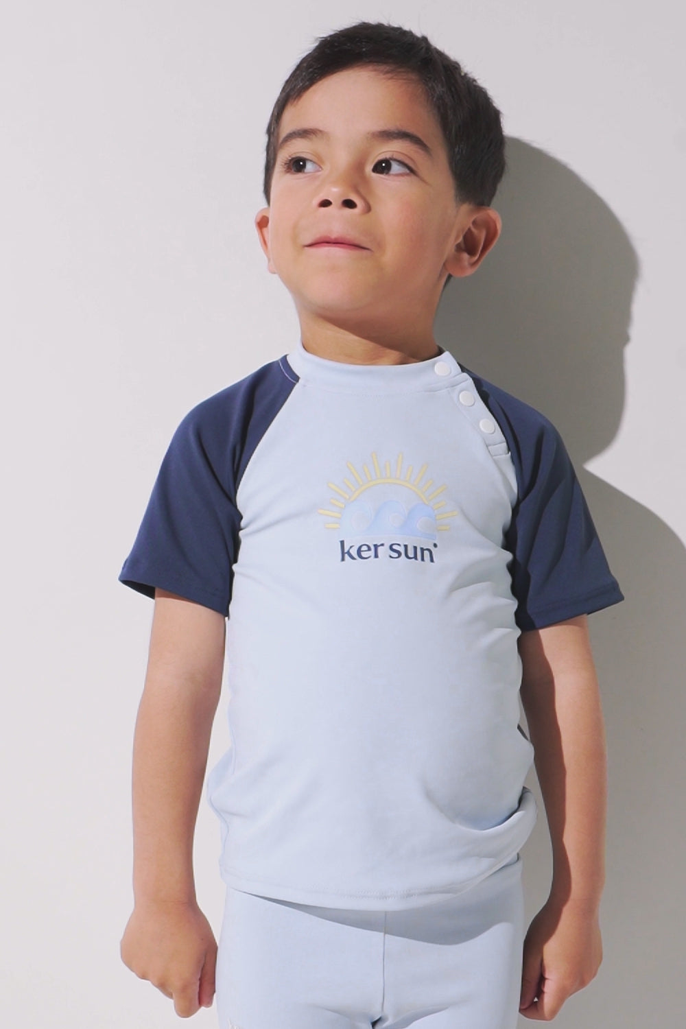 T-shirt de bain anti-UV Samoa pour enfant, léger, UPF 50+, couleur bleu clair avec manches bleu marine.
